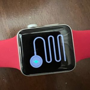 Apple Watch 3 Series 38mm, with red band and a charging cable.